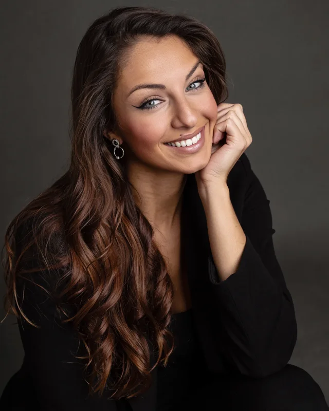 Retrato de estudio de Silvia sonriendo con la mano en la mejilla